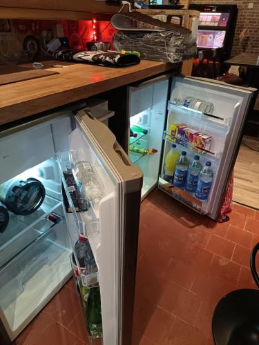 an open refrigerator with its door full of water at La Taverne de la Zibetterie in Saint-Privé