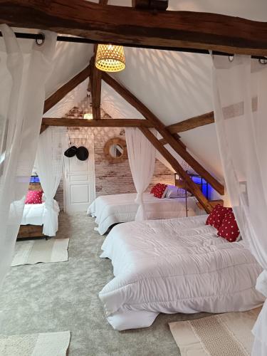 a bedroom with four beds in a attic at La Taverne de la Zibetterie in Saint-Privé