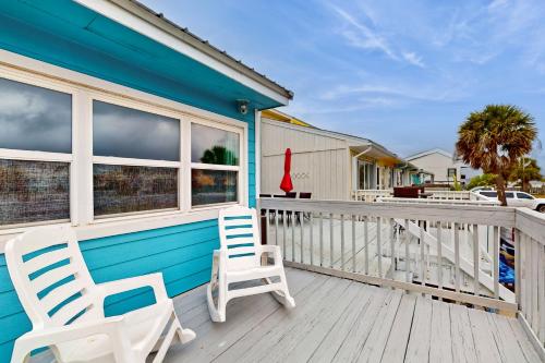 two chairs sitting on the front porch of a blue house at Seas the Day in Navarre