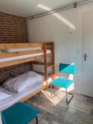 1 Etagenbett und 2 Stühle in einem Zimmer in der Unterkunft Meno Mosso in Sint Maartensvlotbrug