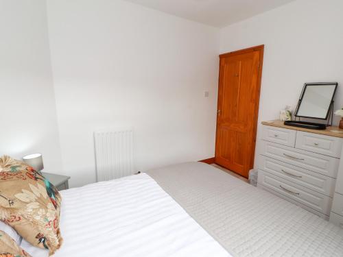 a bedroom with a bed and a dresser with a television at Eusebank in Pooley Bridge
