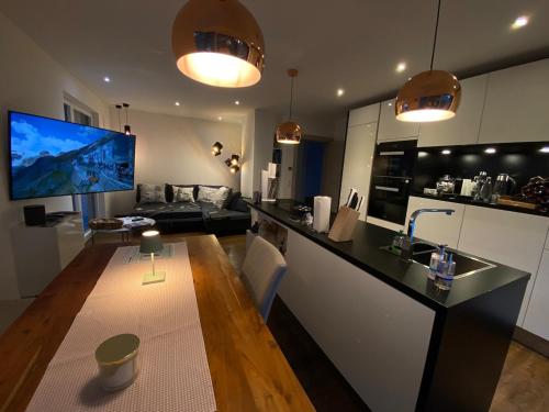 a kitchen and living room with a tv and a counter at Inntal Alpin Apartments - Hohe Munde in Telfs