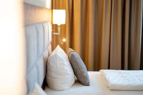 a hotel room with a bed with pillows on it at Korbstadthotel Krone in Lichtenfels