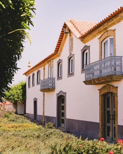 a white house with a balcony on a hill at Casal de Tralhariz - Douro Valley in Tralhariz