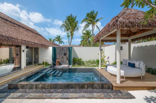 a villa with a swimming pool with a bed and a deck at JW Marriott Maldives Kaafu Atoll Island Resort in Male City