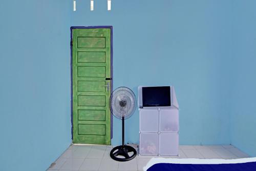 een kamer met een groene deur en een ventilator bij SPOT ON 91918 Najla Guest House Syariah in Parit