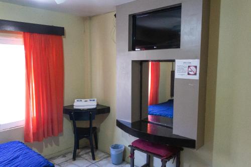 a room with a tv and a table and a table sidx sidx sidx at OYO Hotel Colón, Plaza Bicentenario, Zacatecas Centro in Zacatecas