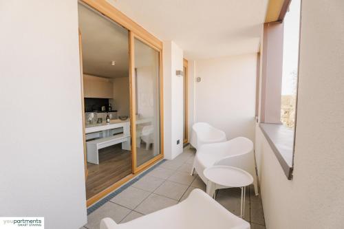 ein kleines Zimmer mit weißen Stühlen und einer Küche in der Unterkunft 139 QM - Exklusiv auf 2 Etagen - Werse Loft by youpartments in Münster