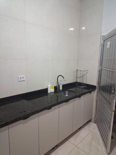 a white kitchen with a sink and a shower at Doce Lar 58- Casa Evento in Cabo de Santo Agostinho