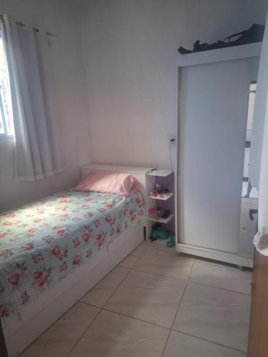 a bedroom with a bed with a floral comforter at Doce Lar 58- Casa Evento in Cabo de Santo Agostinho