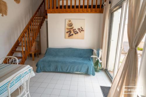 - une chambre avec un lit bleu et un escalier dans l'établissement Maison 6 personnes à 300m de la mer, à Vias