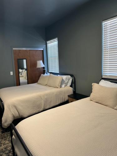a bedroom with two beds and two windows at Hidden Gem of the Westside in Providence