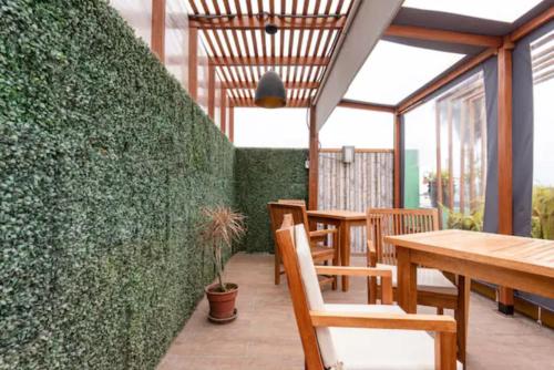 a restaurant with tables and chairs and a green wall at Classy Andino & primer piso, 2 dormitorios in Lima