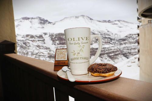a cup of coffee and a donut on a table at HOM I Studio SKI OUT 3PAX en Valle de Condores 1 in Farellones
