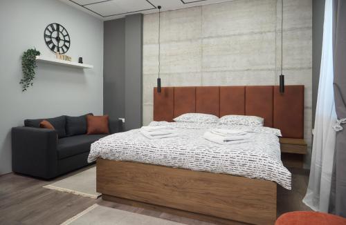 a bedroom with a bed and a couch at Brent Boutique Apartments in Novi Sad