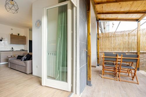 a living room with a glass door and a table and chairs at Confort with Garden in Fiumicino Airport