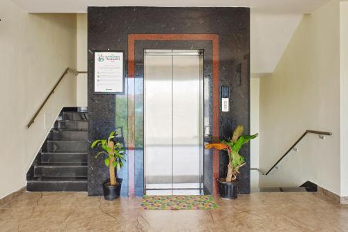 an elevator in a building with two potted plants at Treebo Premium Ocean Echo, Rushikonda in Rushikonda