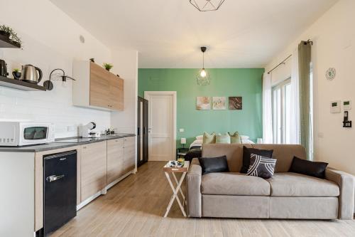 a living room with a couch and a kitchen at Confort with Garden in Fiumicino Airport