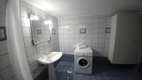 a bathroom with a washing machine and a sink at Eva's House in Kissamos