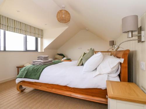 a bedroom with a bed with white sheets and pillows at The Cabin at Ropewalk in St. Agnes