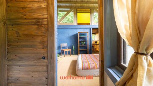 a door leading into a room with a bedroom at Chale na Mata Atlantica com rio e imersao natural in Garuva