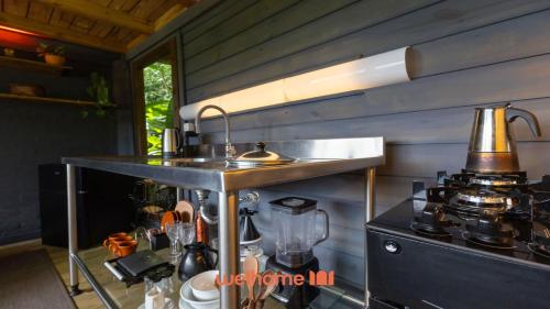 a kitchen with a counter with a sink and a blender at Chale na Mata Atlantica com rio e imersao natural in Garuva