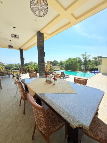 a patio with a table and chairs and a pool at Sea View Luxury Mansion, Pool & Jacuzzi - Koh Chang in Ko Chang