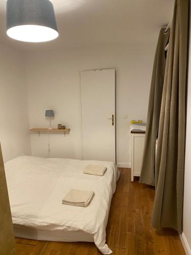 une chambre avec un lit avec deux serviettes dessus dans l'établissement Next castle park studio, à Saint-Cyr-lʼÉcole