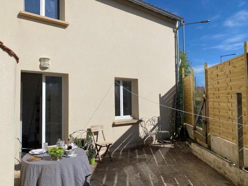une table dans la cour d'une maison blanche dans l'établissement Next castle park studio, à Saint-Cyr-lʼÉcole