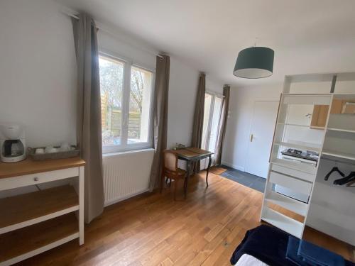 - un salon avec un bureau et une fenêtre dans l'établissement Next castle park studio, à Saint-Cyr-lʼÉcole