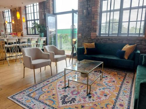 a living room with a couch and a table and chairs at Converted factory loft apartment - Free parking with no height restrictions x 2 in Bristol