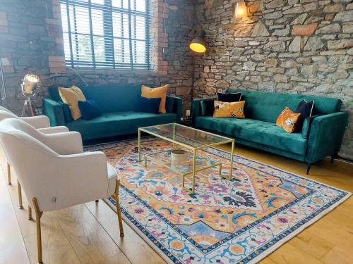 a living room with blue couches and a rug at Converted factory loft apartment - Free parking with no height restrictions x 2 in Bristol