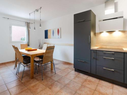 une cuisine avec une table et des chaises dans une pièce dans l'établissement Villa 3 pièces à Narbonne-Plage, animaux acceptés - FR-1-409-276, à Narbonne