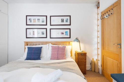 a bedroom with a bed with four pictures on the wall at The Mews Flat, near Clifton Suspension Bridge with off-street parking in Bristol