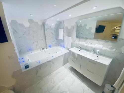 une salle de bain blanche avec une baignoire et un lavabo dans l'établissement Ici, dort un Yeti, à Planay