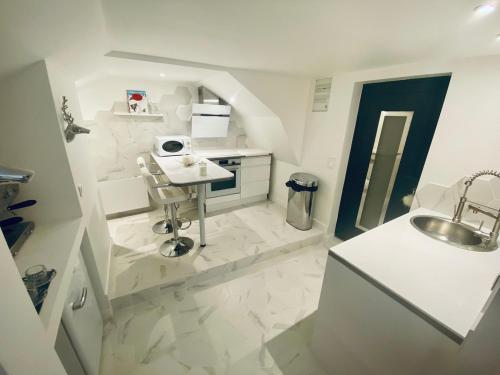 - une petite salle de bains blanche avec lavabo dans l'établissement Ici, dort un Yeti, à Planay