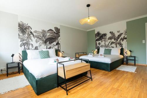 deux lits dans une chambre aux murs verts dans l'établissement Évasion à Oiry Villa Madeline, à Oiry