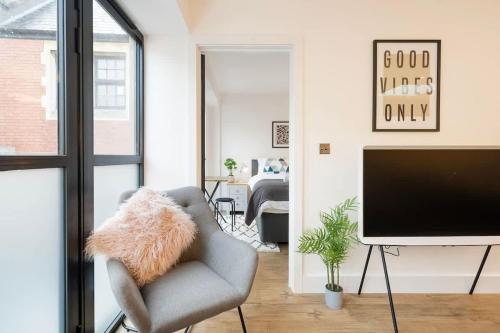 sala de estar con silla y TV de pantalla plana en The Upside Down Eco House - Free parking with no height restrictions, en Bristol