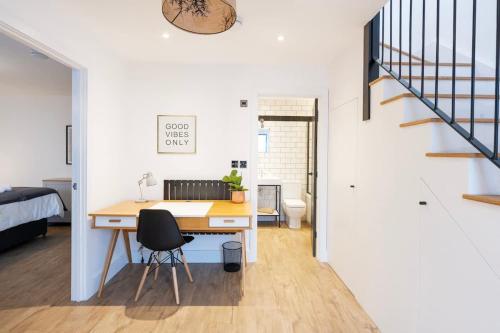 a home office with a desk and a staircase at The Upside Down Eco House - Free parking with no height restrictions in Bristol