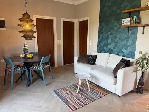a living room with a white couch and a table at Villa Feronia Samos in Mesókampos