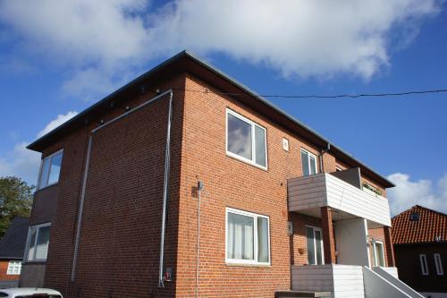 a red brick house with a black roof at Strandby Kirkevej 270 Ground floor id 021 in Esbjerg