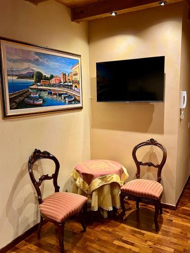 a room with two chairs and a table and a tv at Apartment Manzoni Bardolino Center in Bardolino