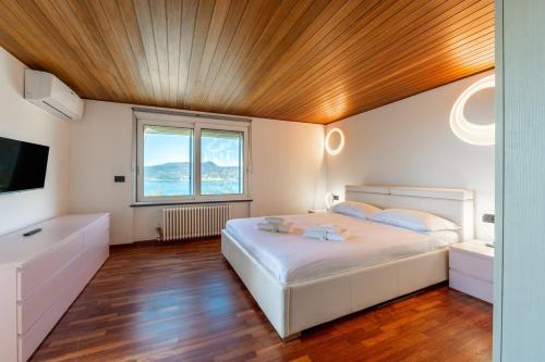 a bedroom with a white bed and a wooden ceiling at Valerie Luxury House And Spa in Zoagli