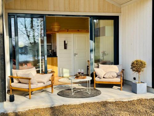 a patio with two chairs and a table at Hällesdalens Gård - semesterhus i Bohuslän in Svenshögen
