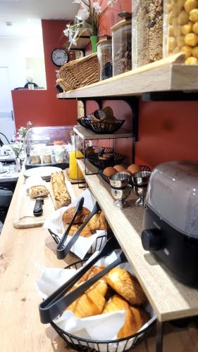 - un buffet avec beaucoup de pain et de viennoiseries dans l'établissement Hotel Bastille Secret, à Paris