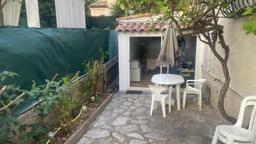 un patio avec une table, des chaises et un parasol dans l'établissement Studio Elisa, à Antibes