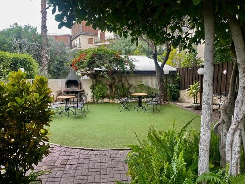 a garden with tables and chairs on a lawn at Beit Immanuel in Tel Aviv