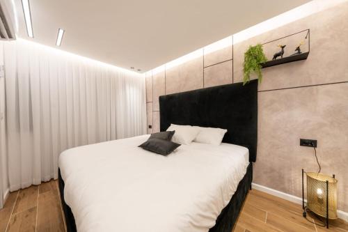 a bedroom with a white bed with a black headboard at tzfat regal in Safed