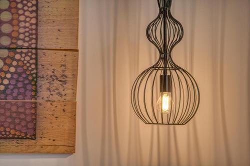 a pendant light hanging from a wall next to a curtain at Santa Maria Hotel in Elia Beach