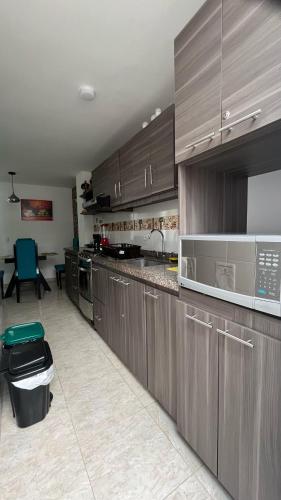 a kitchen with wooden cabinets and a counter top at confortable apto integrado con la naturaleza y muy tranquilo perfecto para descansar in Socorro
